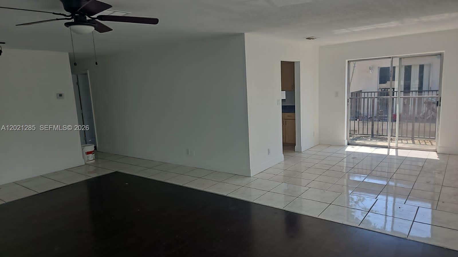 An interior view shows a living area with dark flooring, white tile, and a sliding door — 5300 NW 18th Ct # 4I, Lauderhill FL 33313, LAUDERHILL, FL