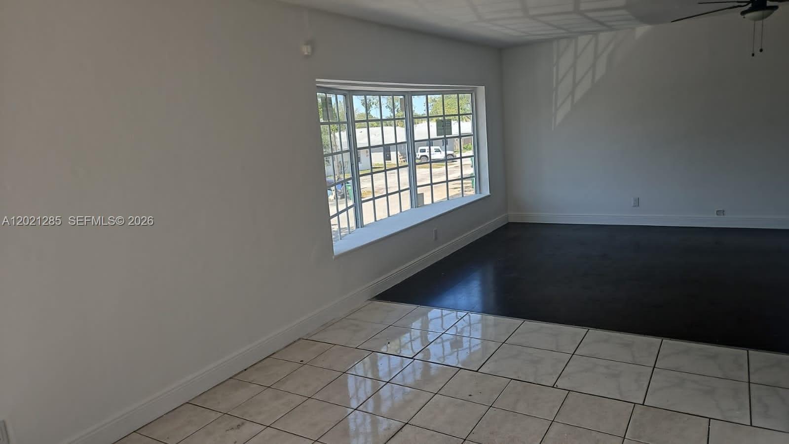 A room with white walls, a large bay window, and a split tile and dark floor — 5300 NW 18th Ct # 4I, Lauderhill FL 33313, LAUDERHILL, FL