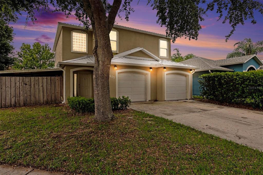A two-story house with a two-car garage and a large tree in the front yard — 2415 SAINT PAULS DRIVE, TITUSVILLE, FL