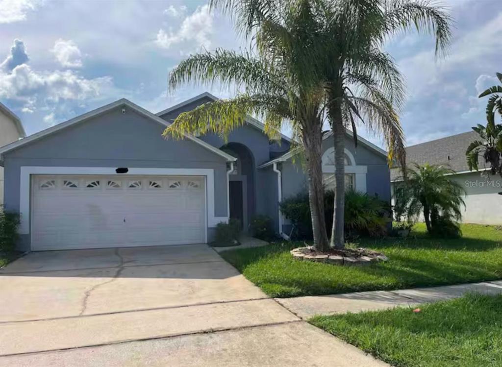 A single-story house with a gray exterior, a two-car garage, and a palm tree — 622 EAGLE POINTE S, KISSIMMEE, FL