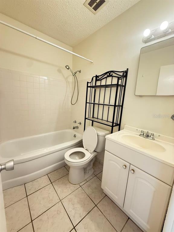 A bathroom features a white bathtub, a toilet, a vanity with a sink, and shelving — 4032 57TH STREET N UNIT 264, KENNETH CITY, FL