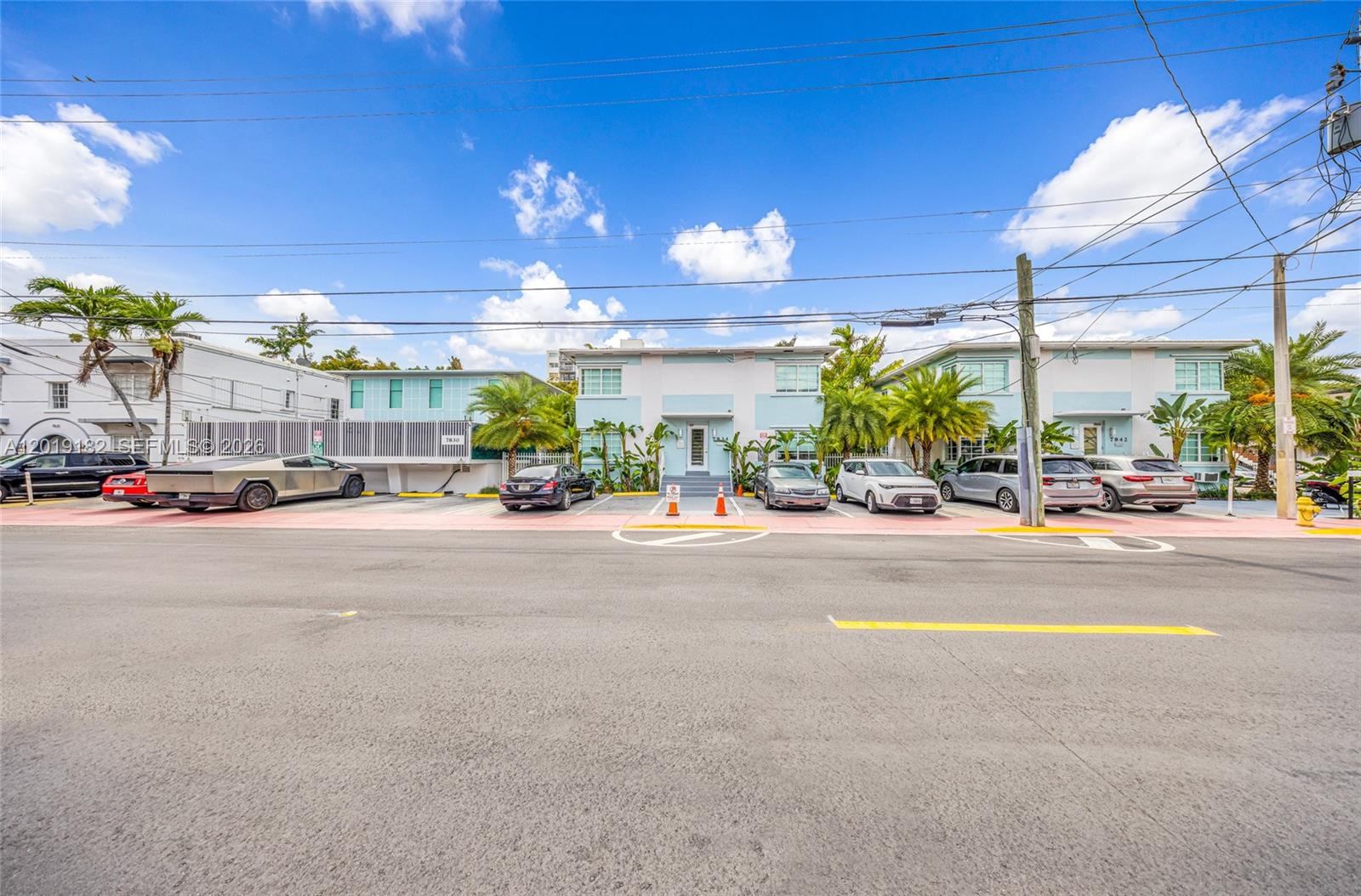 A light blue two-story apartment building with palm trees and parked cars in front — 7830 Abbott Ave, Miami Beach FL 33141, MIAMI BEACH, FL