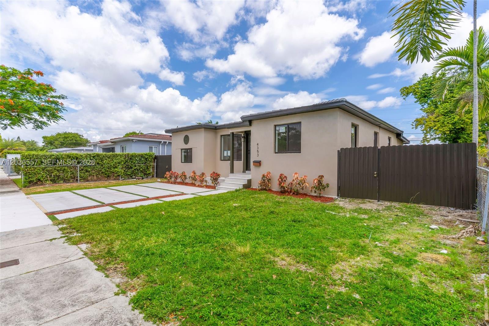 A single-story house with a beige exterior, a concrete driveway, and a dark privacy fence — 4353 SW 2nd St, Miami FL 33134, MIAMI, FL
