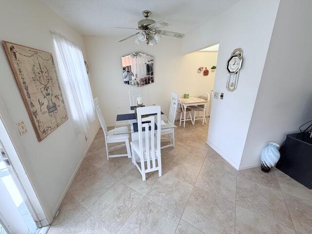 A dining area features a glass table, white chairs, tile flooring, and a ceiling fan — 174 Prescott I, Deerfield Beach FL 33442, DEERFIELD BEACH, FL