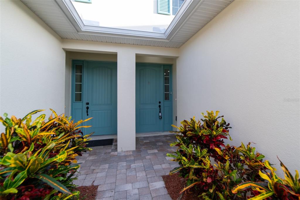 A teal front door with a side window sits in a recessed entryway — 1017 STEVEN PATRICK AVENUE, INDIAN HARBOUR BEACH, FL