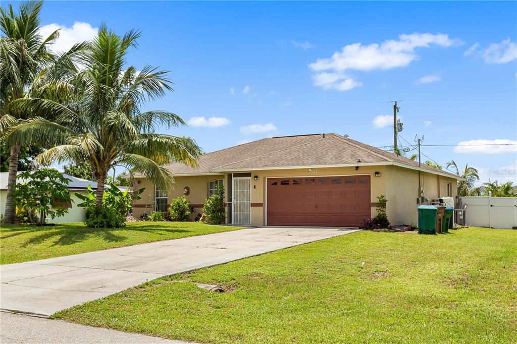 A single-story house with a tan exterior, a brown roof, and a two-car garage — 1728 NE 22ND TERRACE, CAPE CORAL, FL