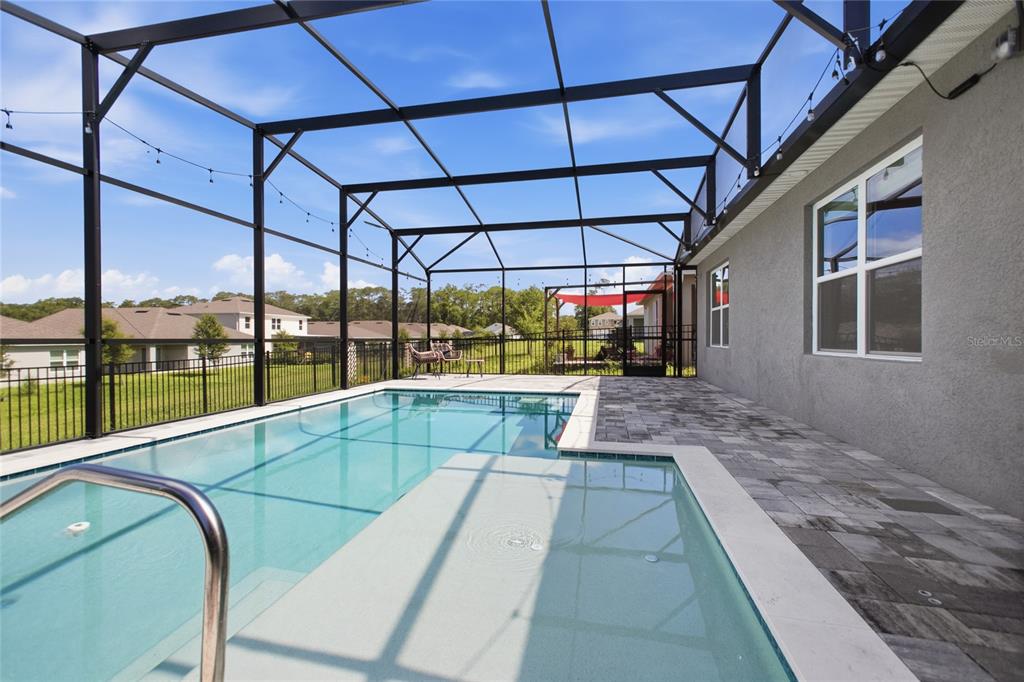 A screened-in pool patio features a rectangular swimming pool with a shallow tanning ledge — 489 LADY GRACE PLACE, DELAND, FL