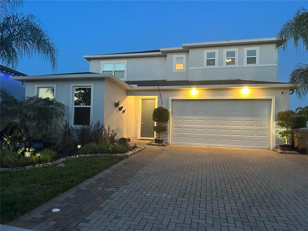 A two-story house with a paved driveway, a two-car garage, and a landscaped front yard — 2104 STILLWOOD WAY, ST CLOUD, FL