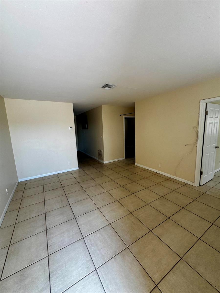 An empty room with beige walls and light-colored square floor tiles — 2824 N Dixie Highway, Boca Raton FL 33431, BOCA RATON, FL