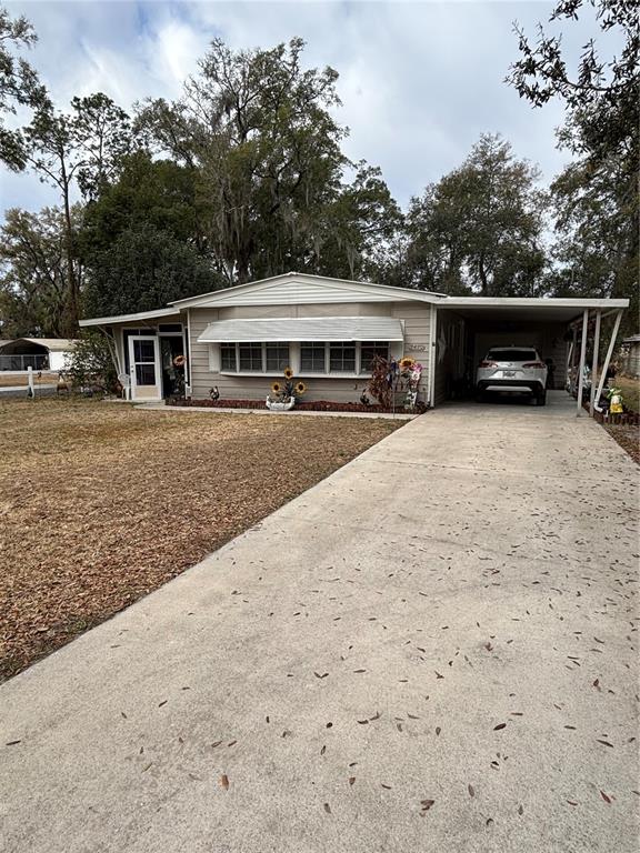 A single-story house with a carport, concrete driveway, and a front lawn with trees — 2420 SE 175TH TERRACE, SILVER SPRINGS, FL