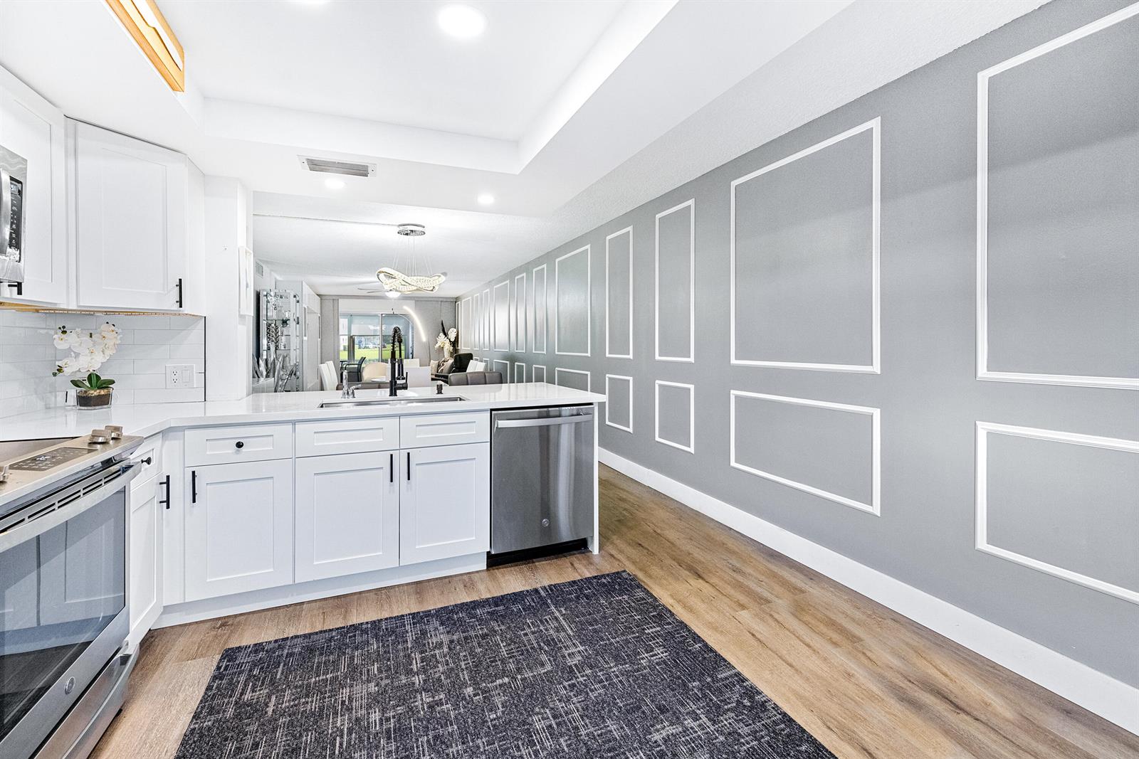 A kitchen features white cabinets, stainless steel appliances, and a gray wall with molding — 1018 Guildford A, Boca Raton FL 33434, BOCA RATON, FL