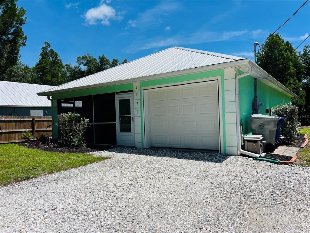 A light green detached garage with a white metal roof and a gravel driveway — 8170 130TH STREET, SEBASTIAN, FL