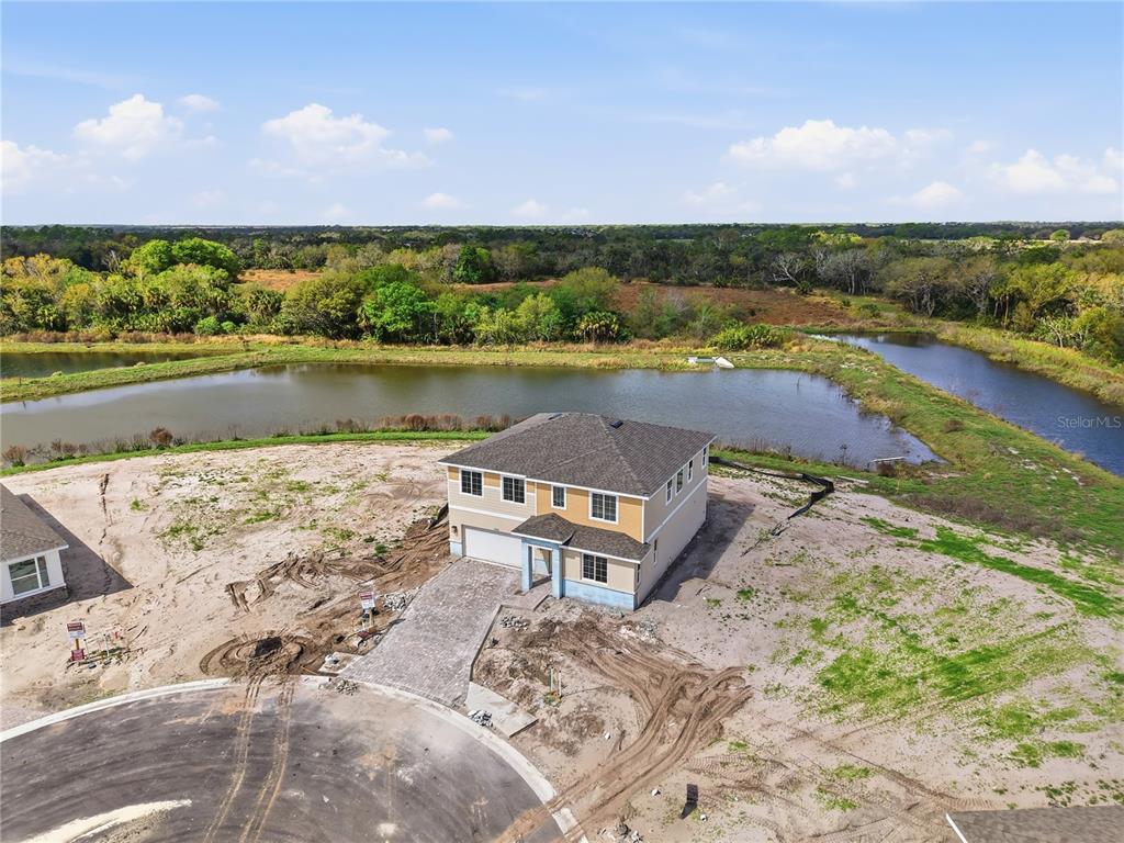 An aerial view shows a newly constructed two-story house situated on a lot near water — 14510 BANKS COURT, PARRISH, FL