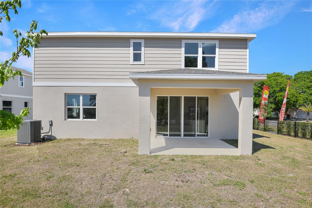 The exterior of a two-story house features a covered patio and a fenced backyard — 14510 BANKS COURT, PARRISH, FL
