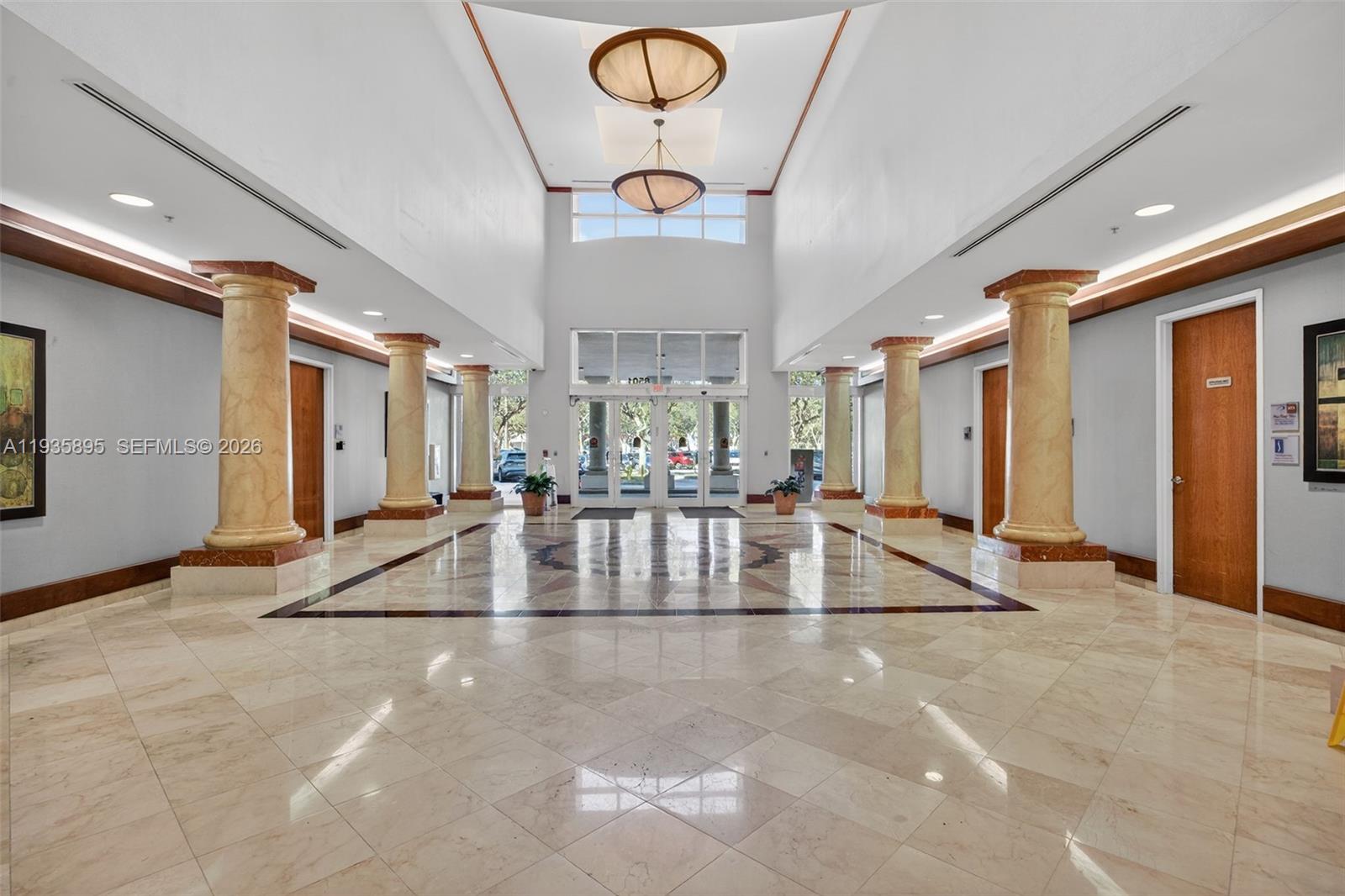 A spacious lobby features marble floors, decorative columns, and two large hanging pendant lights — 8501 SW 124th Ave # 201, Miami FL 33183, MIAMI, FL