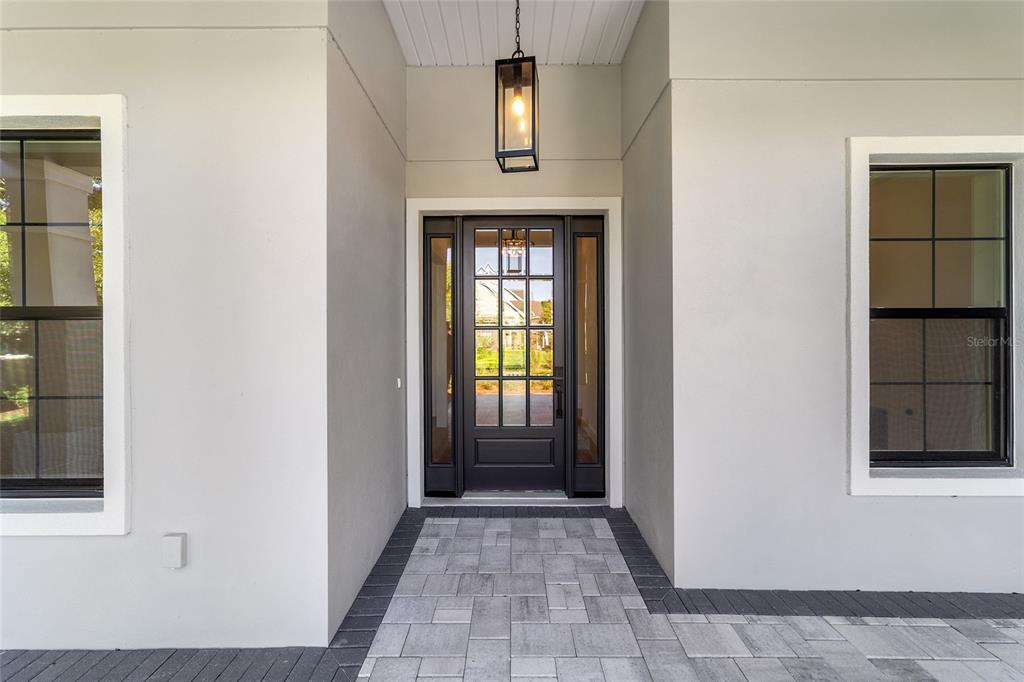 A front entryway features a dark-framed glass door with sidelights and a hanging lantern light — 5775 SW 43RD PLACE, OCALA, FL