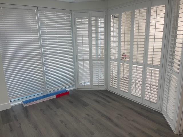 A room with gray wood-look flooring, white horizontal blinds, and white plantation shutters — 5220 University Drive # 109c, Davie FL 33328, DAVIE, FL