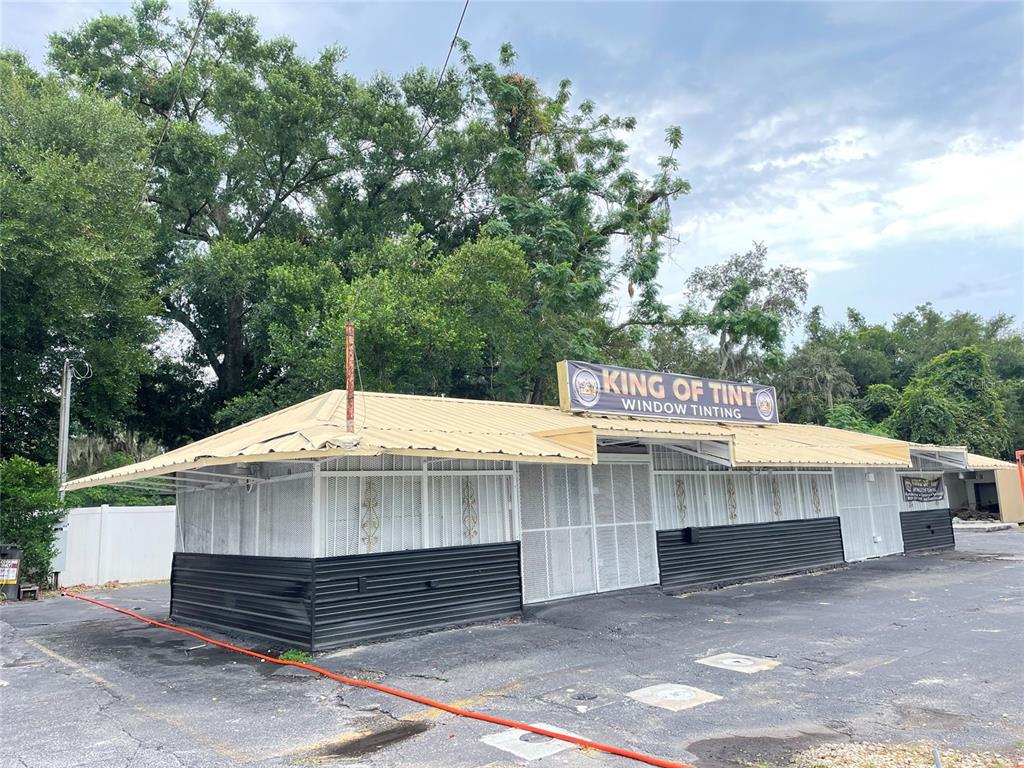 A single-story commercial building with a metal roof and white security grilles on the exterior — 7817 N 56TH STREET, TAMPA, FL