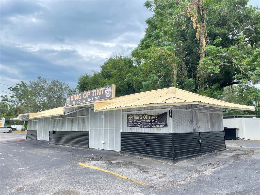 A single-story commercial building with a metal roof and white security grilles over windows — 7817 N 56TH STREET, TAMPA, FL