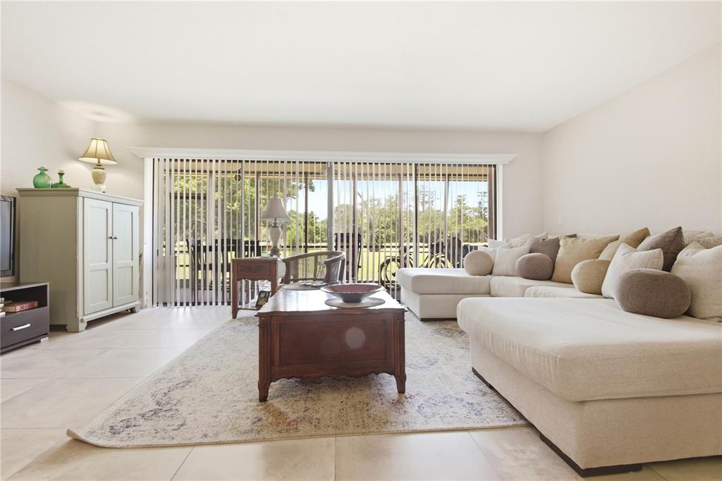 A living room features a large sectional sofa, a wooden coffee table, and sliding glass doors — 260 MICHAELS CIRCLE, OLDSMAR, FL