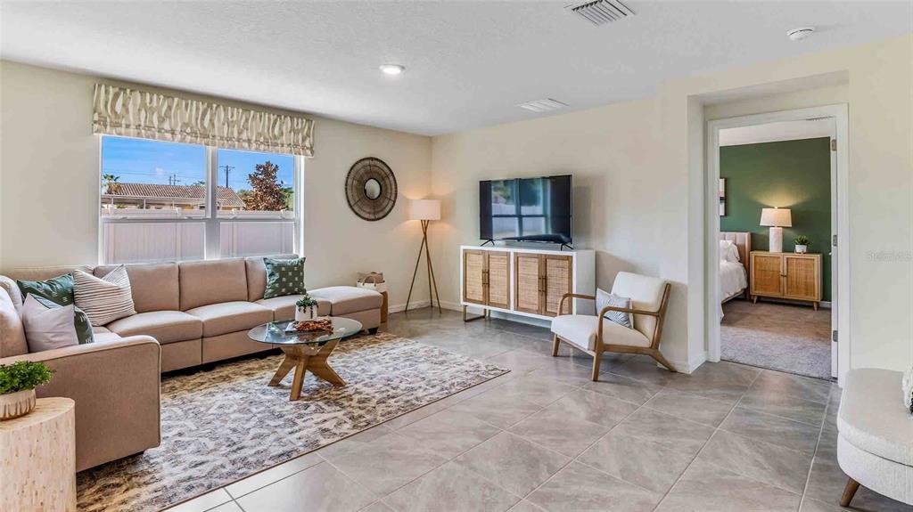 A living room features a beige sectional sofa, a glass coffee table, and tile flooring — 3514 HARVEST GARDENS LOOP, PLANT CITY, FL