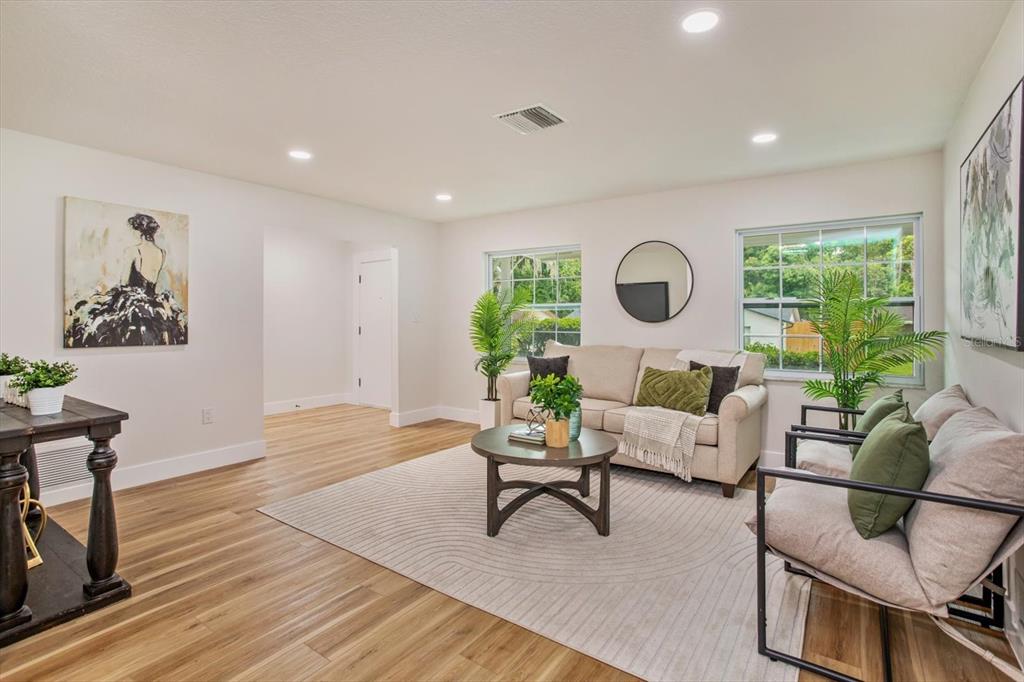 A living room features light wood flooring, a beige sofa, and a round coffee table — 958 ORANGE AVENUE, OVIEDO, FL