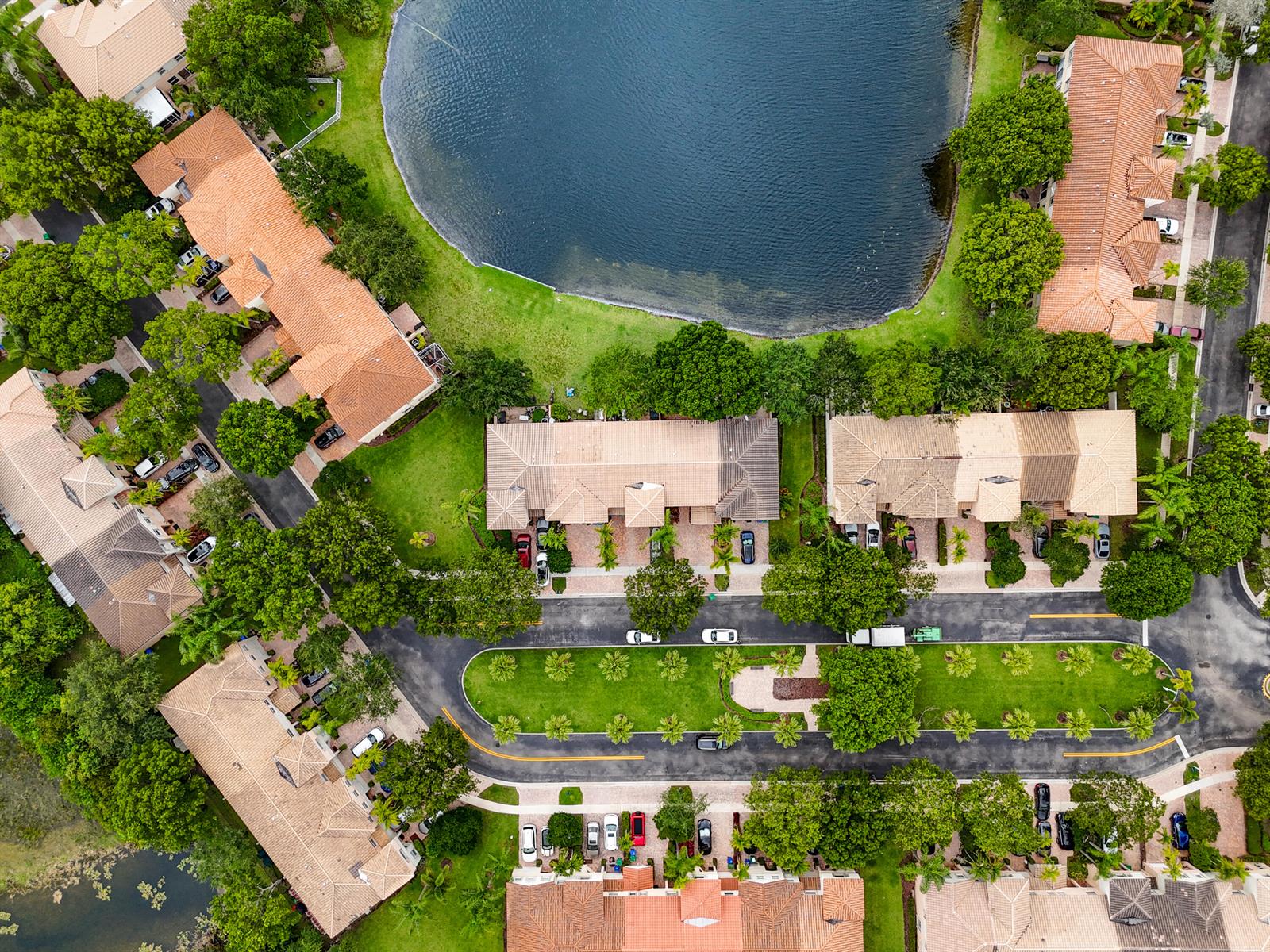 An aerial view shows a residential townhouse complex situated along a large lake — 4735 SW 164th Avenue, Miramar FL 33027, MIRAMAR, FL