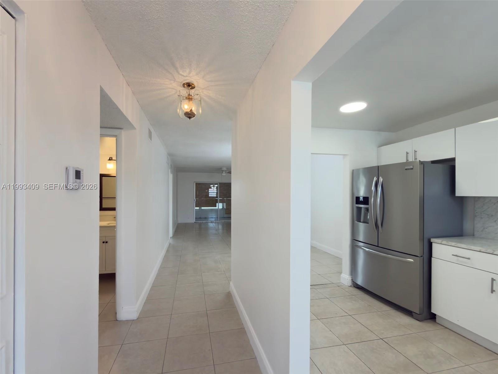 A hallway leads to a living area with a kitchen visible on the right — 609 S State Road 7 # 1C, Margate FL 33068, MARGATE, FL