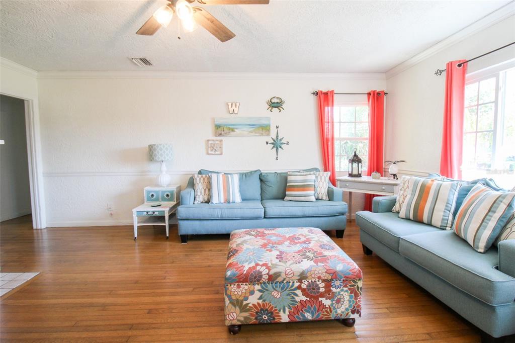 A living room features two blue sofas, a floral ottoman, and hardwood floors — 5812 7TH AVENUE NW, BRADENTON, FL