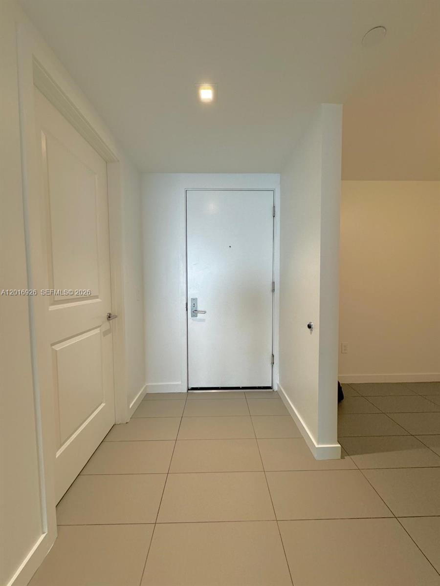 A tiled entryway features a white front door and an adjacent interior door — 1600 NE 1st Ave # 3614, Miami FL 33132, MIAMI, FL