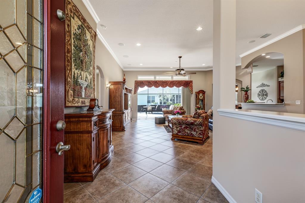 A view from an entryway into a living room with tile floors and patio access — 5530 CELEBRATION WAY, LEESBURG, FL