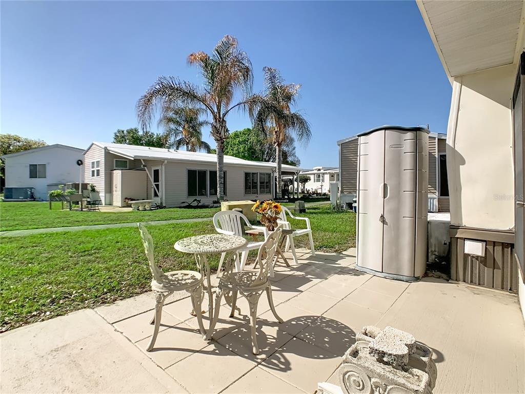 A patio with a small table and chairs sits outside a mobile home — 9000 US HWY 192 UNIT 407, CLERMONT, FL