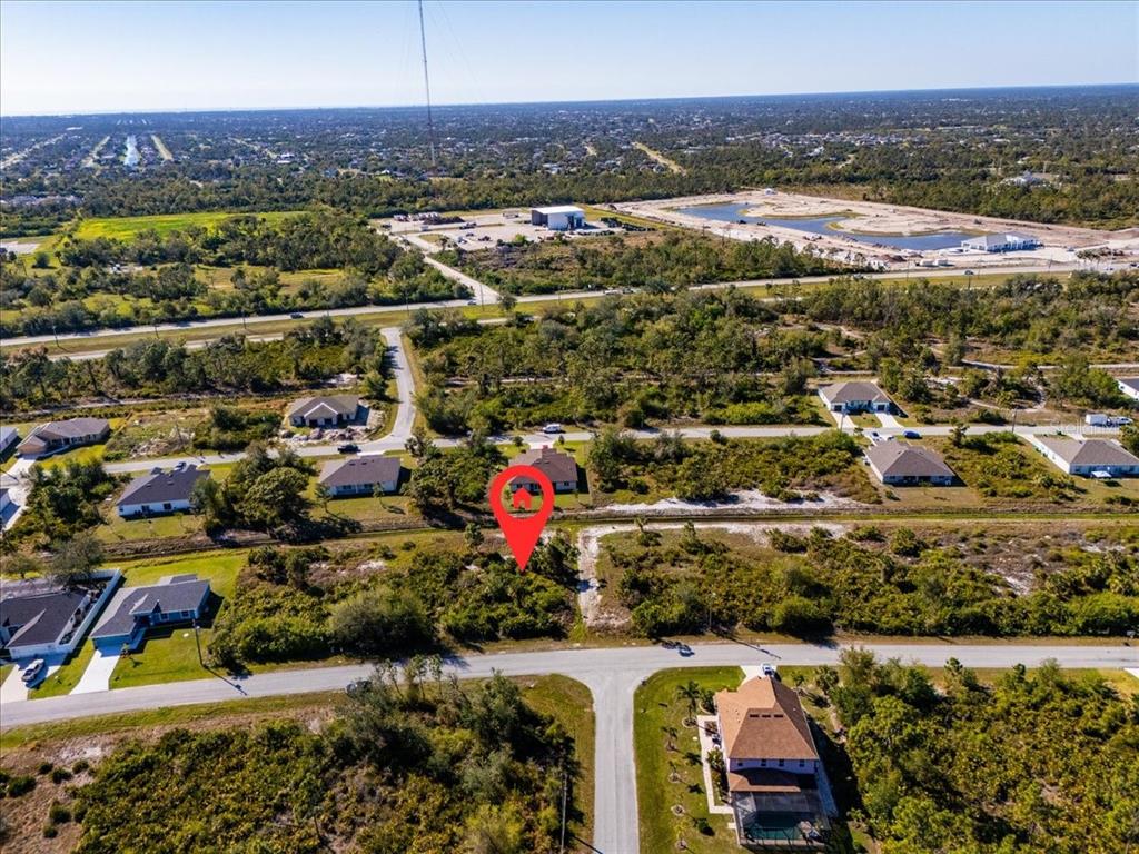 An aerial view shows a residential lot marked with a pin among surrounding houses — 9243 WALDREP STREET, PORT CHARLOTTE, FL