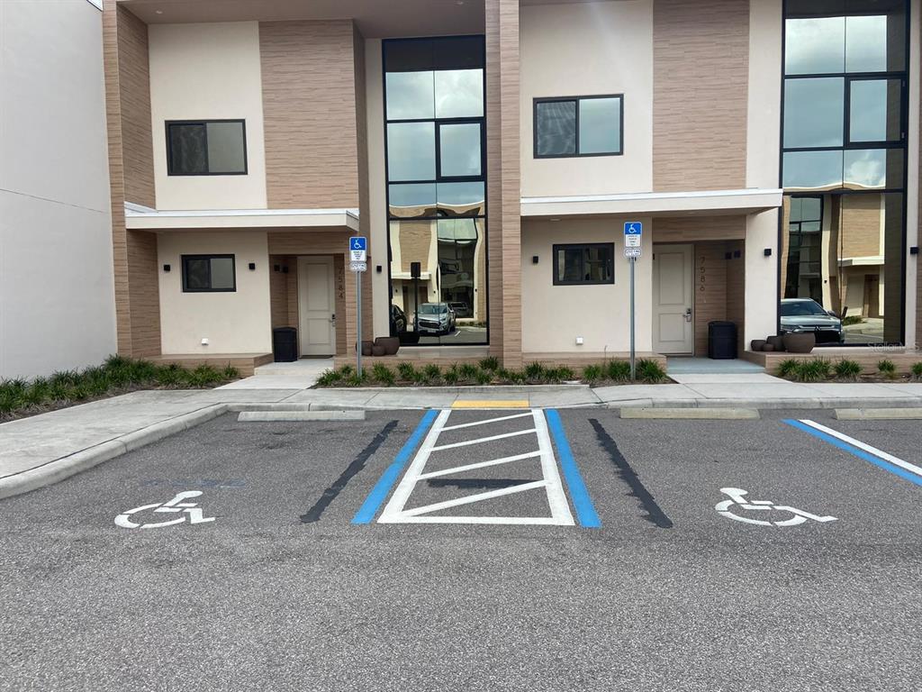 Two modern townhome units feature designated handicap parking spaces in front of their entrances — 7582 BROOKLYN DRIVE, KISSIMMEE, FL