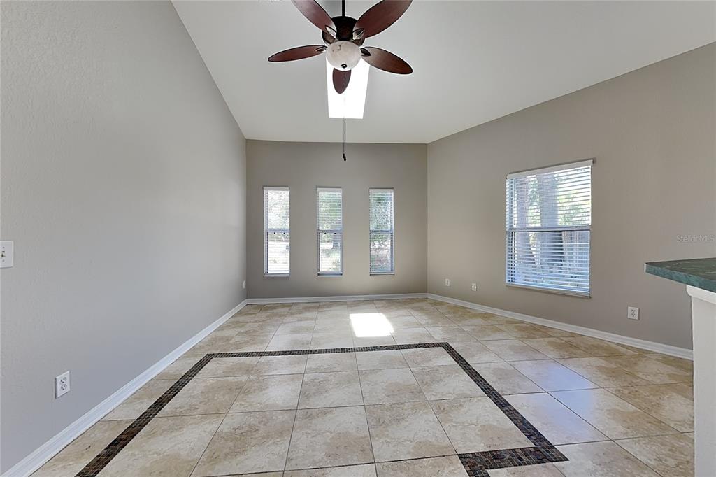 An empty dining room features tile flooring with a decorative border and a ceiling fan — 229 LOOKOUT DRIVE, APOLLO BEACH, FL