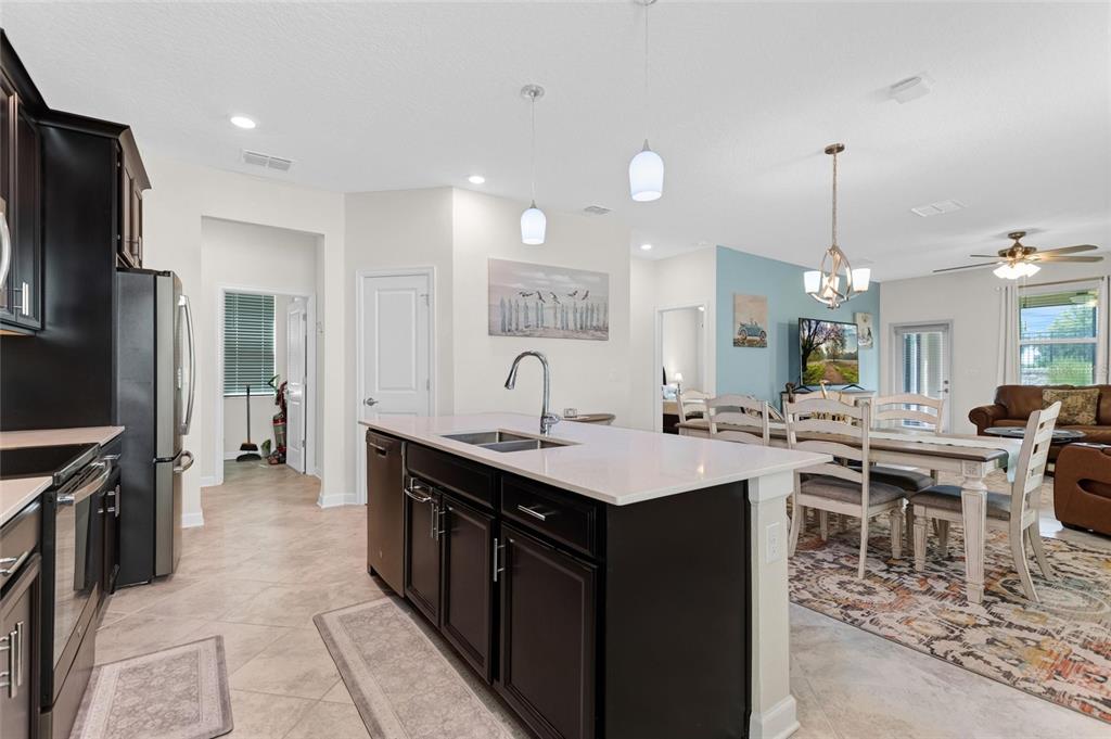 A kitchen island with a white countertop sits in an open-concept living and dining area — 1045 BLACKWOLF RUN RD, DAVENPORT, FL