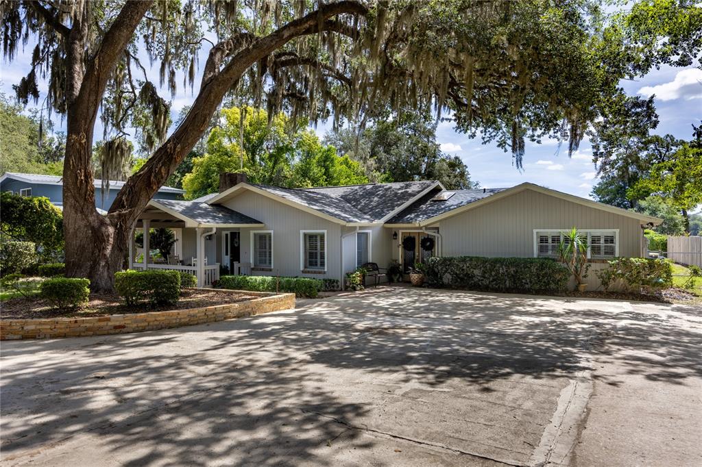 A single-story house with light gray siding and a large oak tree in the front — 3933 SE STATE ROAD 21, KEYSTONE HEIGHTS, FL