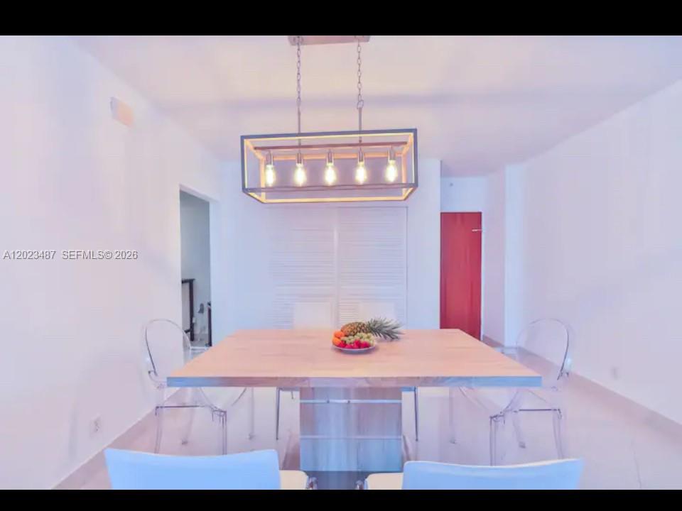 A dining room features a wooden table, clear chairs, and a rectangular pendant light fixture — 4001 S Ocean Dr # 7L, Hollywood FL 33019, HOLLYWOOD, FL
