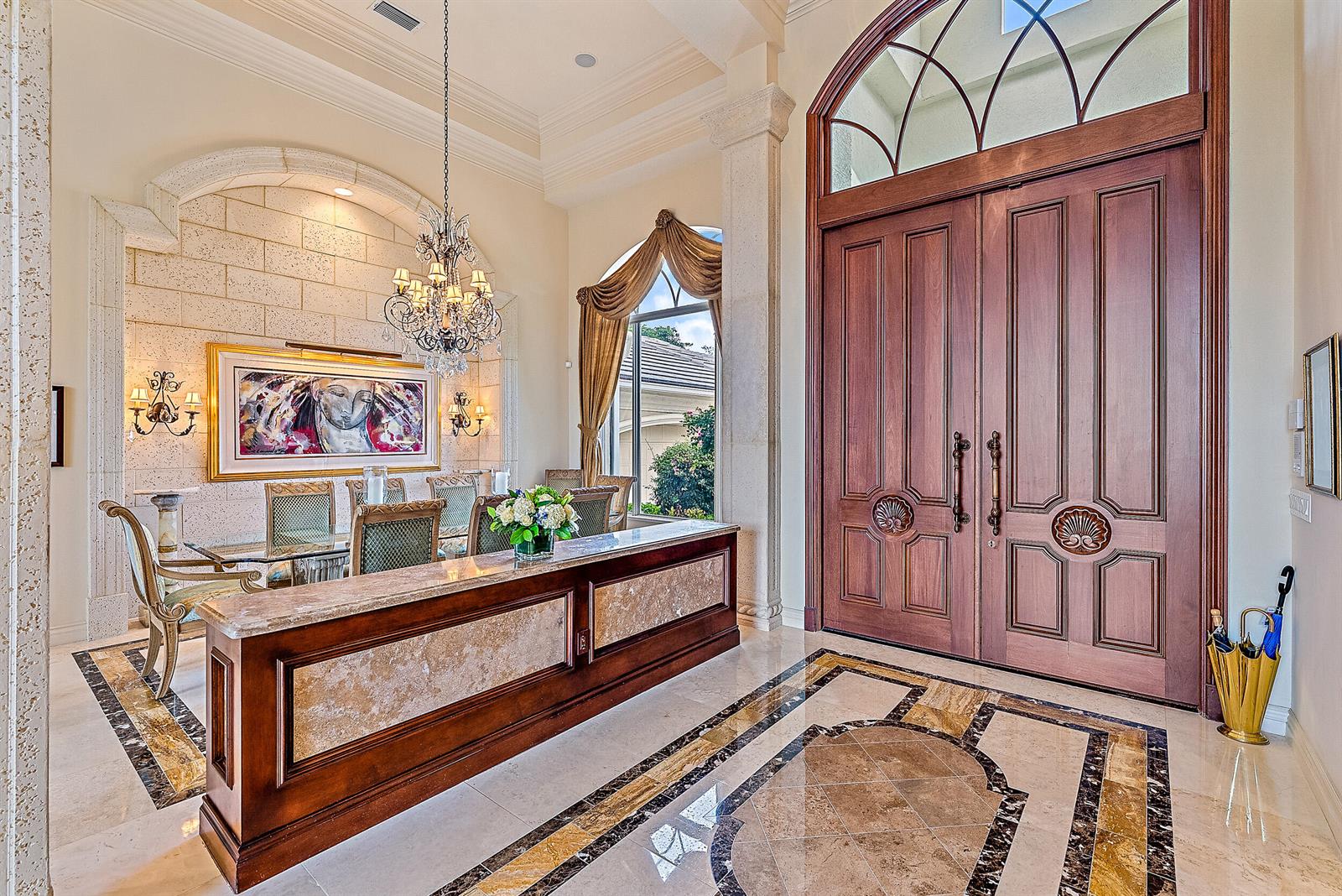 A grand foyer features a marble floor, a wooden reception desk, and large double doors — 12049 SE Intracoastal Terrace, Jupiter FL 33469, JUPITER, FL