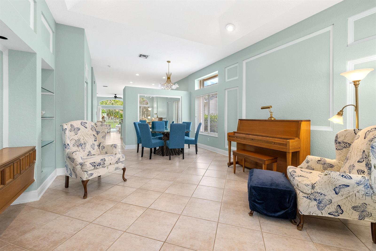 A light blue living and dining area features tile floors, a piano, and patterned armchairs — 6513 Sandpiper Drive, Coconut Creek FL 33073, COCONUT CREEK, FL