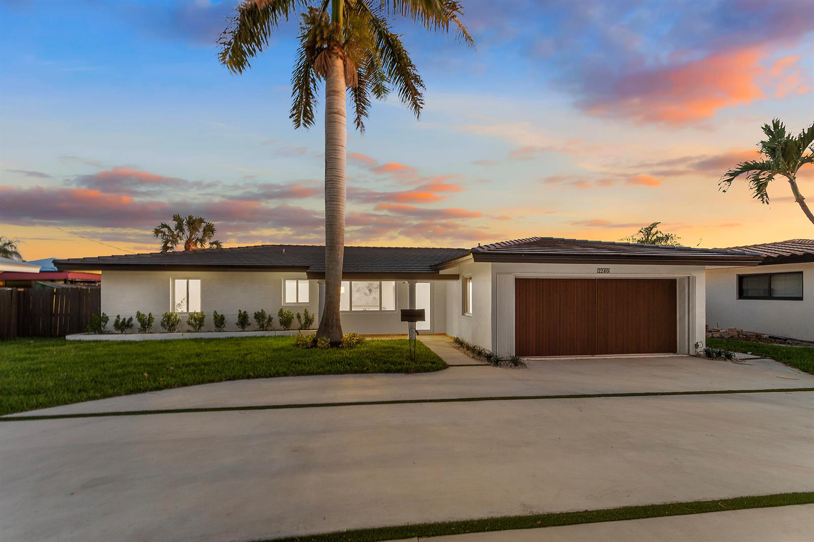 A single-story white house with a slatted wood garage door and a tall palm tree — 2280 SE 10th Court, Pompano Beach FL 33062, POMPANO BEACH, FL