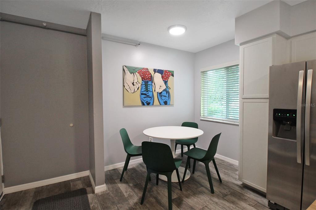 A dining area features a white round table, four green chairs, and pop art — 2124 N TAMIAMI TRAIL UNIT 101, SARASOTA, FL