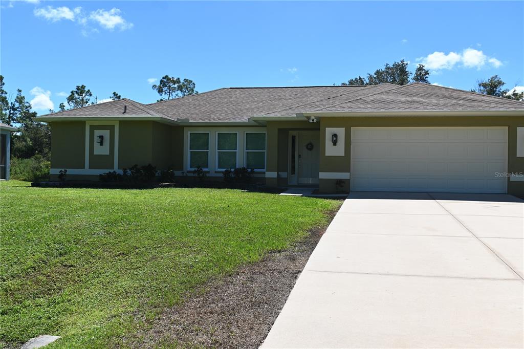 A single-story house with a green exterior, a shingled roof, and a concrete driveway — 5378 DUNSMUIR ROAD, NORTH PORT, FL