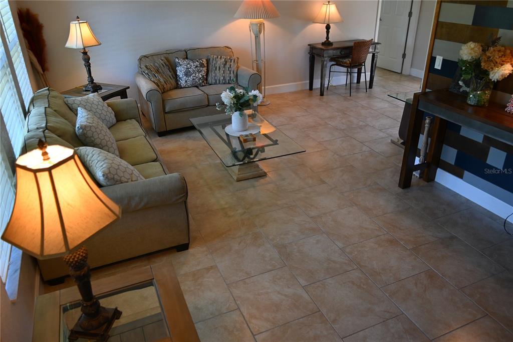 A living room features beige tile flooring, two sofas, a glass coffee table, and lamps — 5378 DUNSMUIR ROAD, NORTH PORT, FL