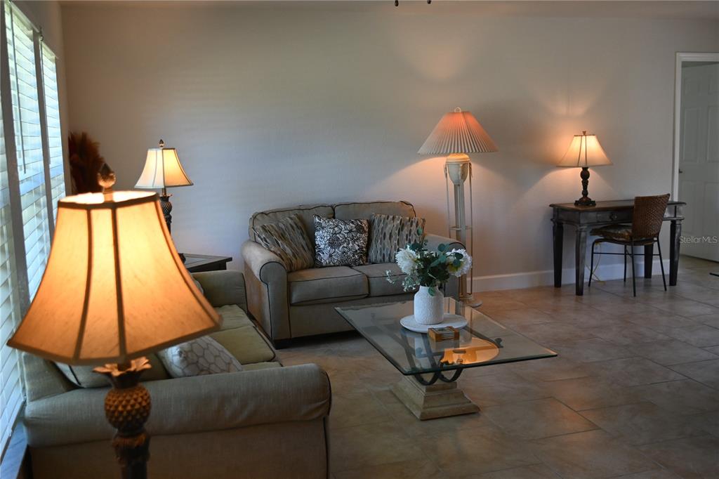 A living room features tile flooring, two sofas, a glass coffee table, and several lamps — 5378 DUNSMUIR ROAD, NORTH PORT, FL