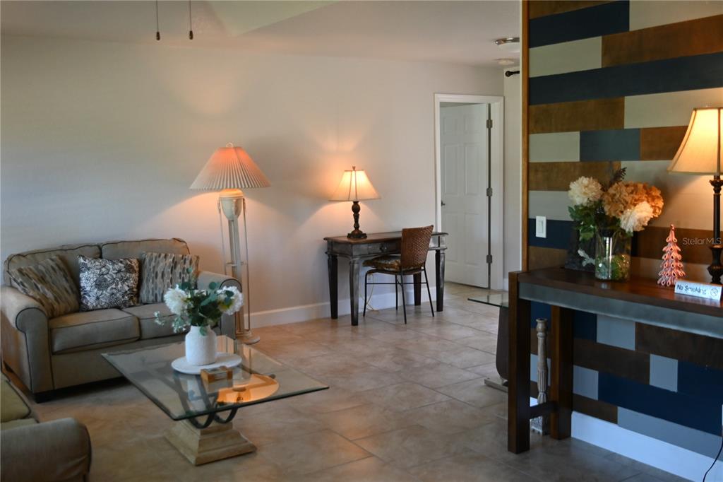 A living room features tile flooring, a beige sofa, a glass coffee table, and a desk — 5378 DUNSMUIR ROAD, NORTH PORT, FL