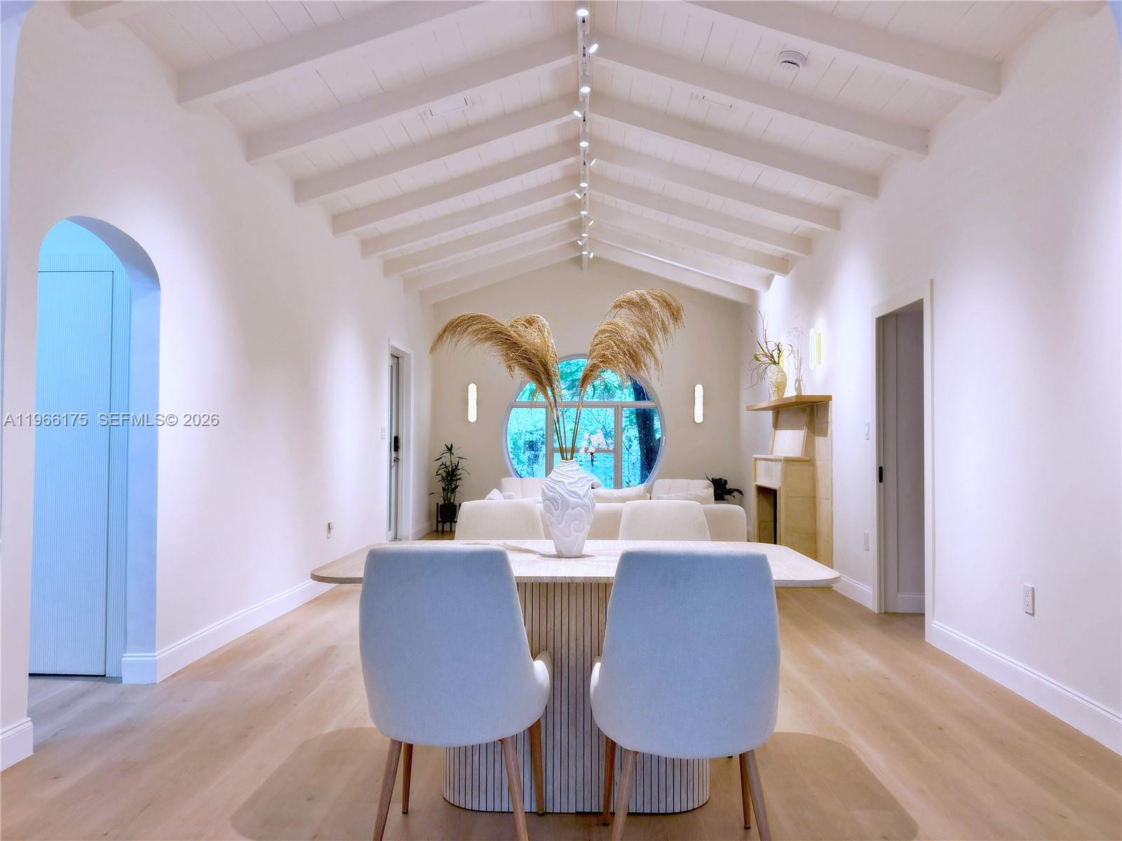 A dining room features a vaulted beamed ceiling, light wood floors, and a circular window — 775 NE 76th St, Miami FL 33138, MIAMI, FL