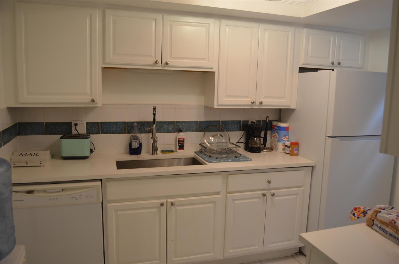 A kitchen with white cabinets, a stainless steel sink, and a white dishwasher and refrigerator — 658 NE 6th Court E, Boynton Beach FL 33435, BOYNTON BEACH, FL