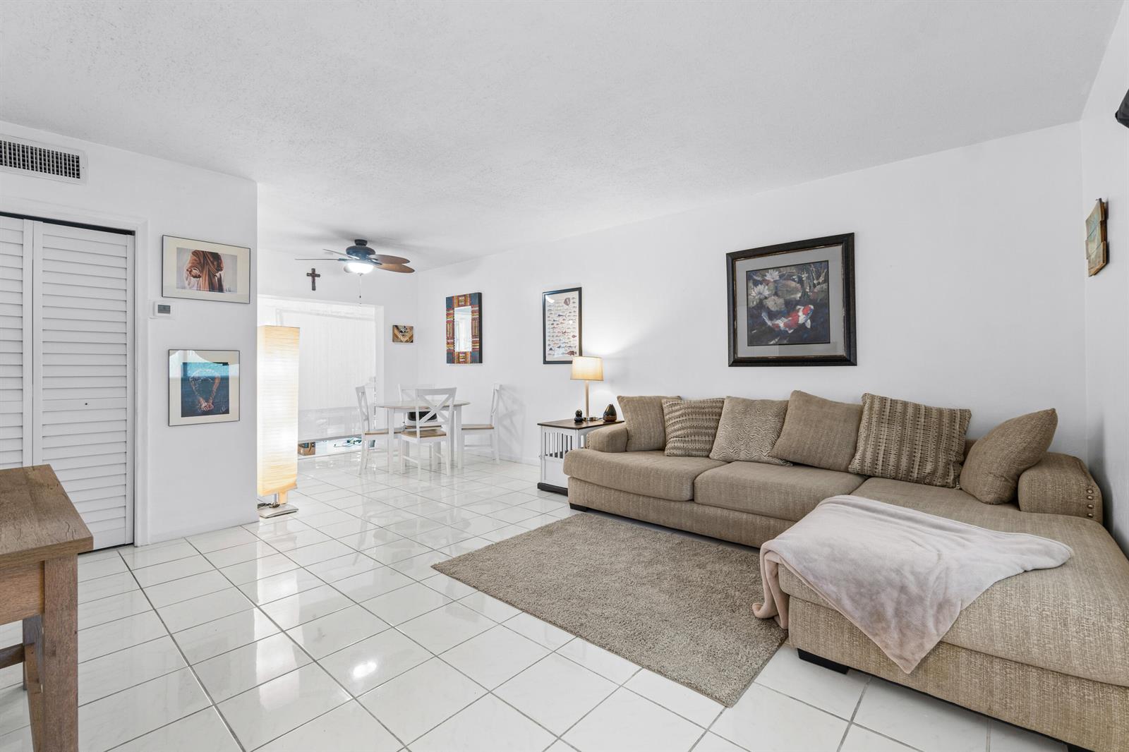 A living room features white tile flooring, a beige sectional sofa, and a dining area — 658 NE 6th Court E, Boynton Beach FL 33435, BOYNTON BEACH, FL