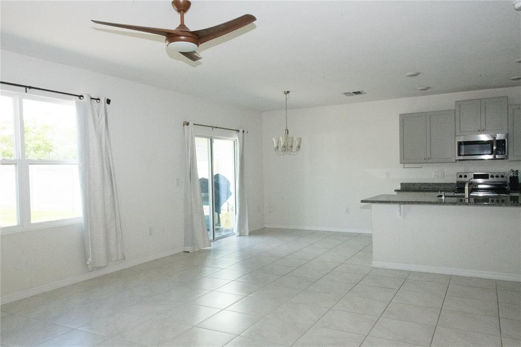 An open-concept living and dining area with tile flooring, a ceiling fan, and a kitchen — 3940 SILVERSTREAM TERRACE, SANFORD, FL